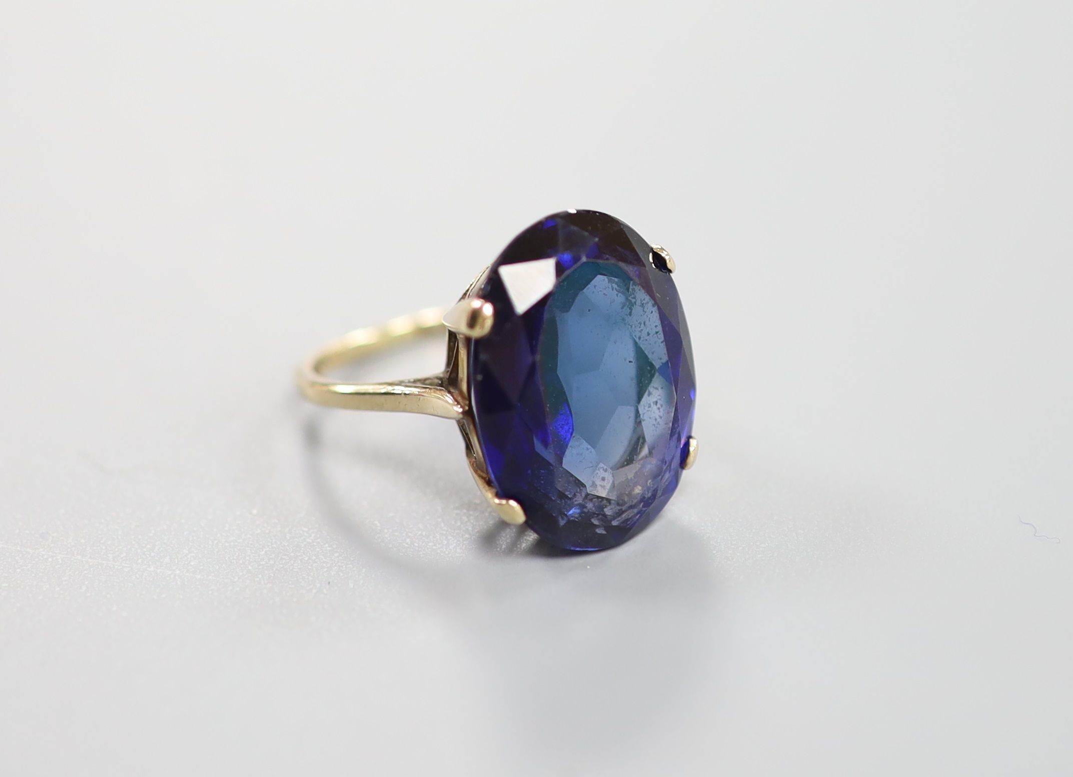 A 9ct gold and oval cut synthetic sapphire set dress ring, size L/M, gross 7.6 grams.